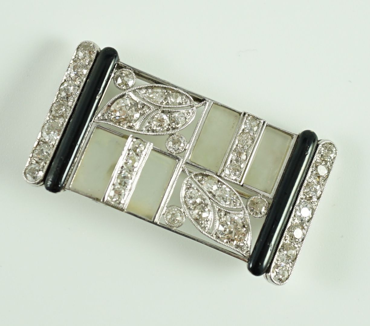 A 1930's/1940's Austro-Hungarian white gold, millegrain set diamond, frosted glass and black enamel rectangular brooch